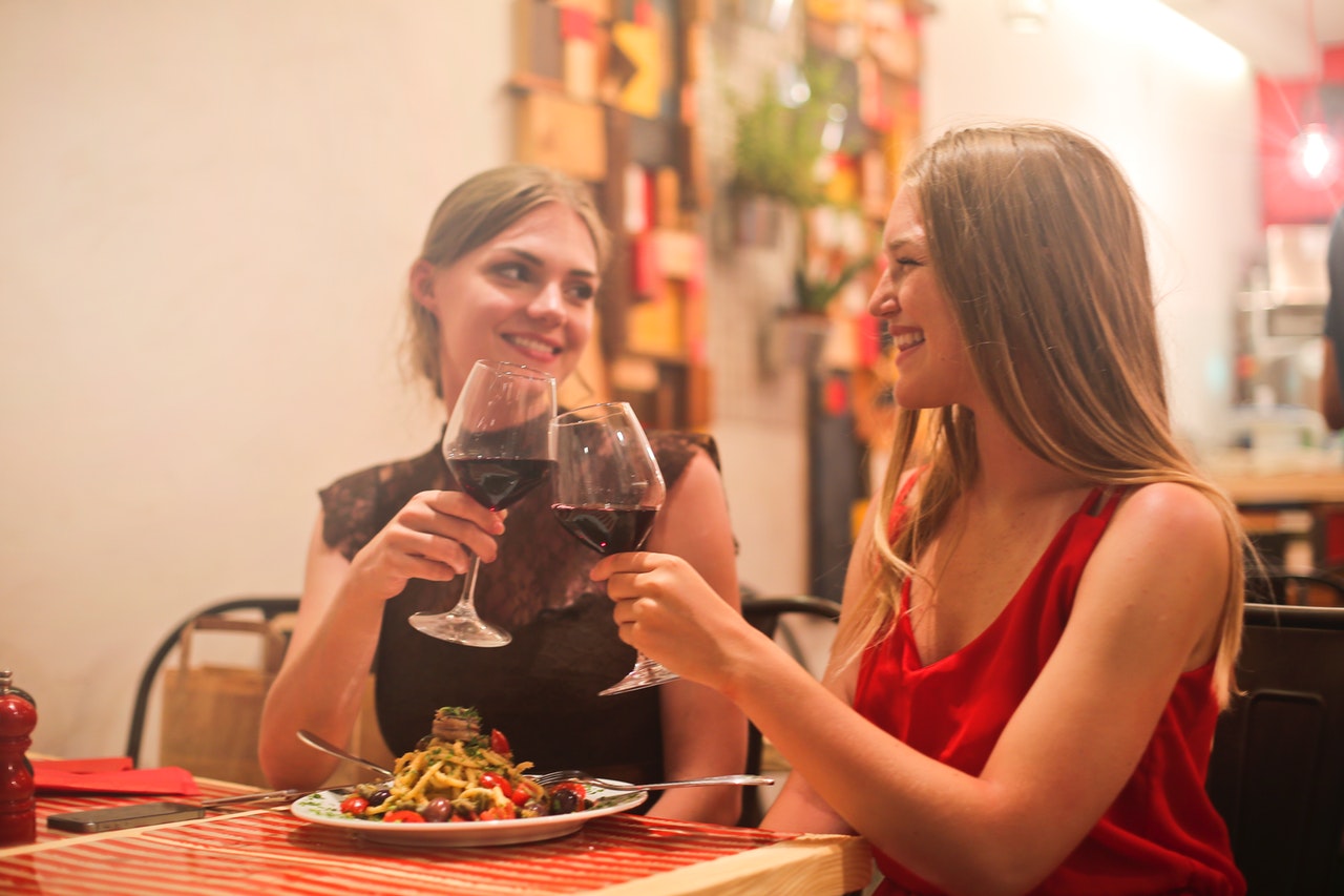 women drinking red wine. they are smiling knowing that red wine could help them fight against depression, anxiety and stress